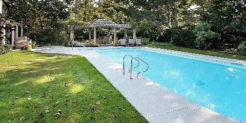 Pool home in Sag Harbor, NY with leaves in the grass.