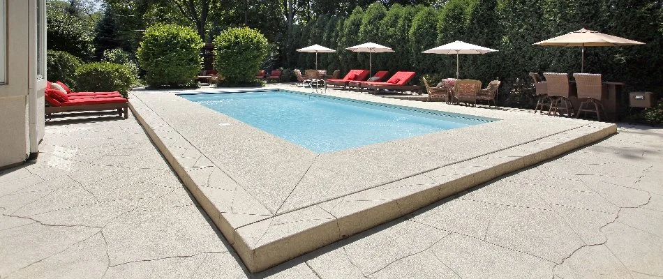 Lounge chairs on decking around a pool in Amagansett, NY.