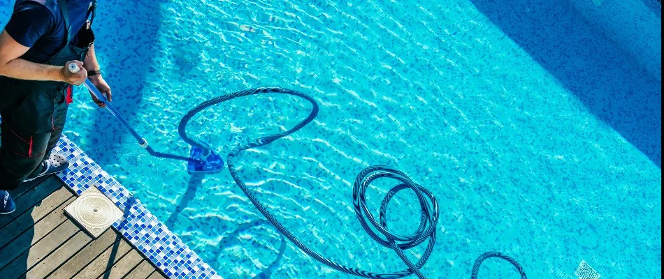 Worker cleaning a pool in Bridgehampton, NY.
