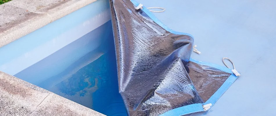 Checking pool cover for the winter.