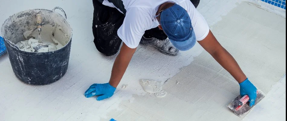 Worker installing tile for a pool in Bridgehampton, NY.
