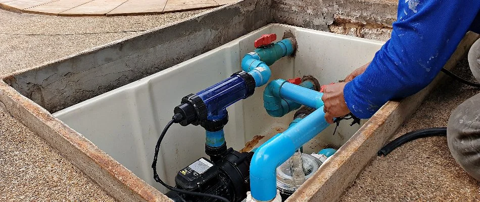 Worker in Bridgehampton, NY, repairing a pool part.